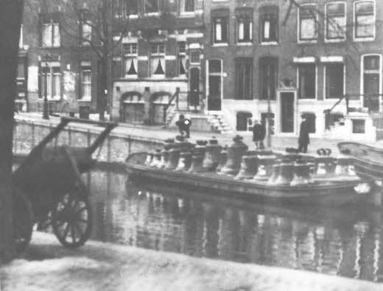 Transport van geroofde klokken per schip in Amsterdam.